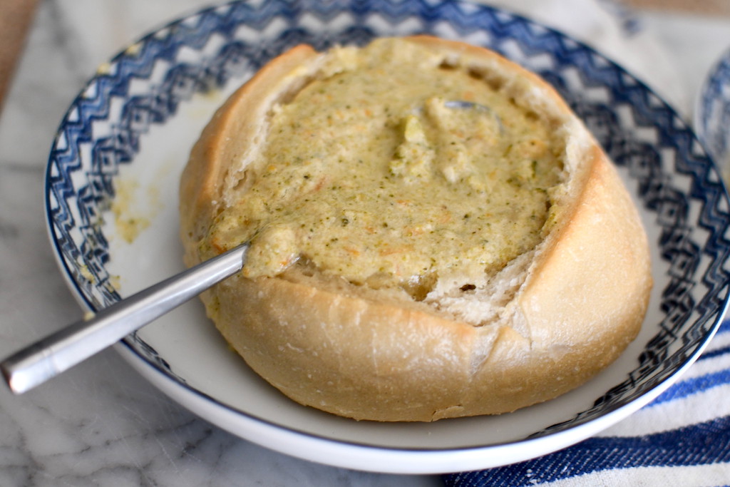 broccoli cheddar soup in bread bowl on plate 
