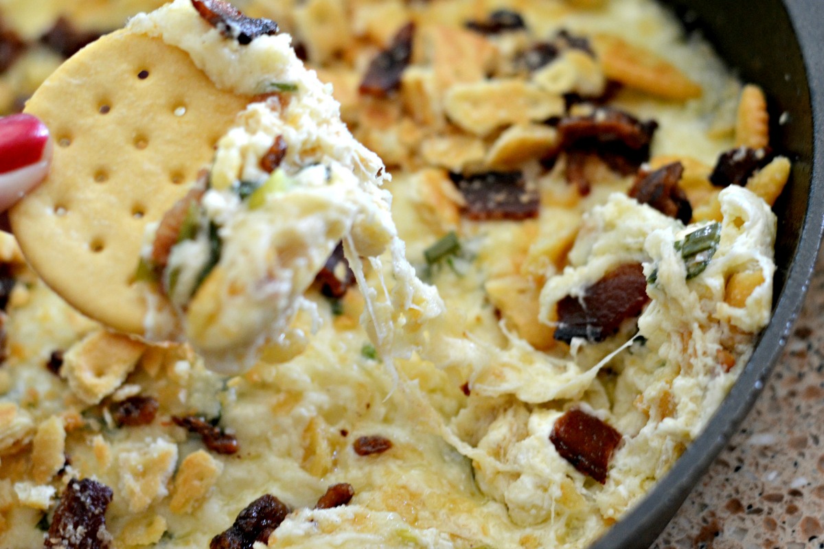 6-ingredient Swiss cheese bacon dip – dipping a cracker in the dip