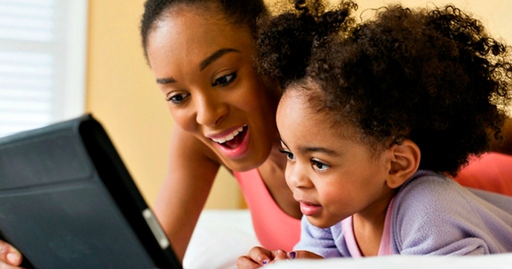 mother and daughter reading together on tablet
