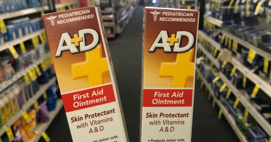 A person holding 2 boxes of A+D ointment tubes