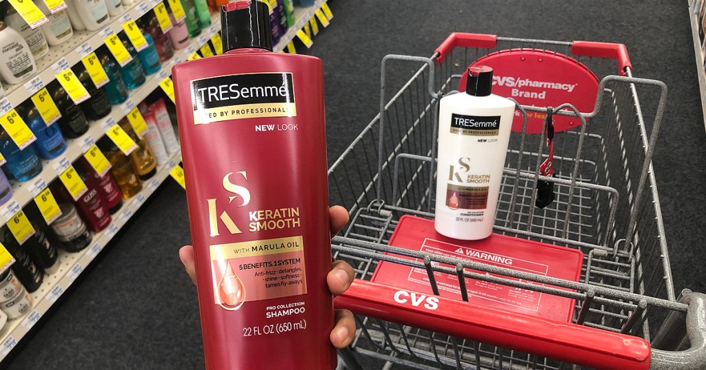 hand holding red bottle of shampoo 