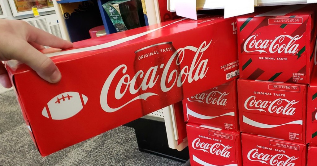 hand pulling box of soda off shelf