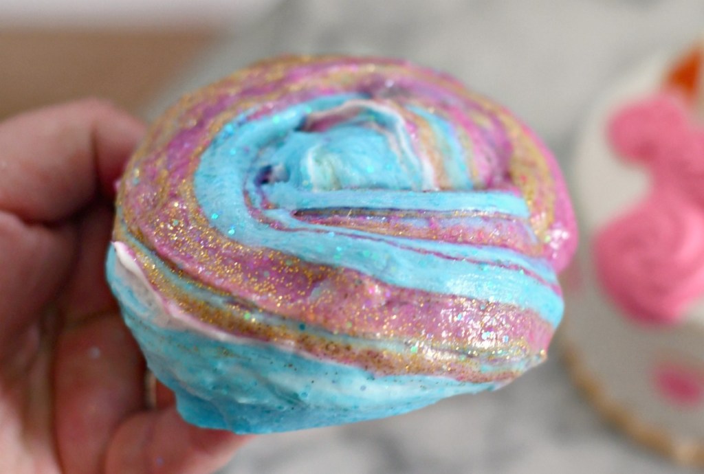 holding swirly colorful unicorn slime