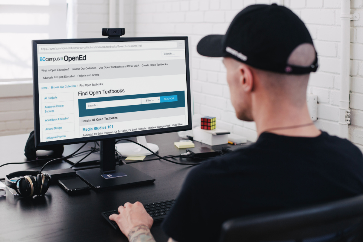 man using computer to search BCcampus OpenEd for free or cheap college textbooks