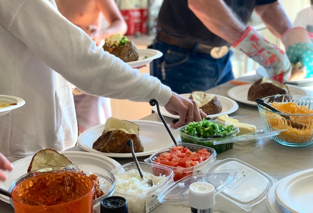people at baked potato bar with toppings