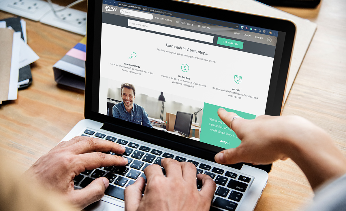 hands typing on laptop keyboard with raise.com on laptop and person pointing at screen