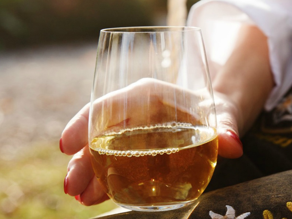hand holding Wine Tumbler filled half way with wine