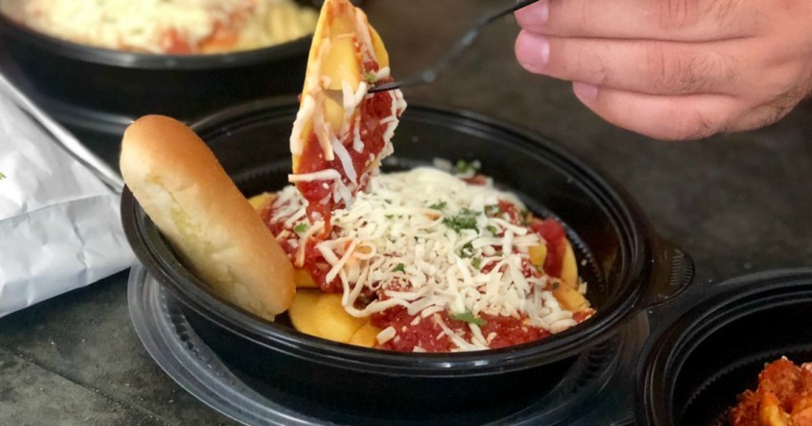 man eating Olive Garden togo order
