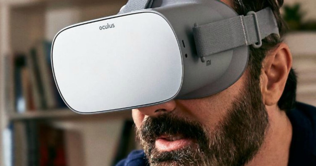 man with beard wearing VR headset over his eyes in front of bookcase