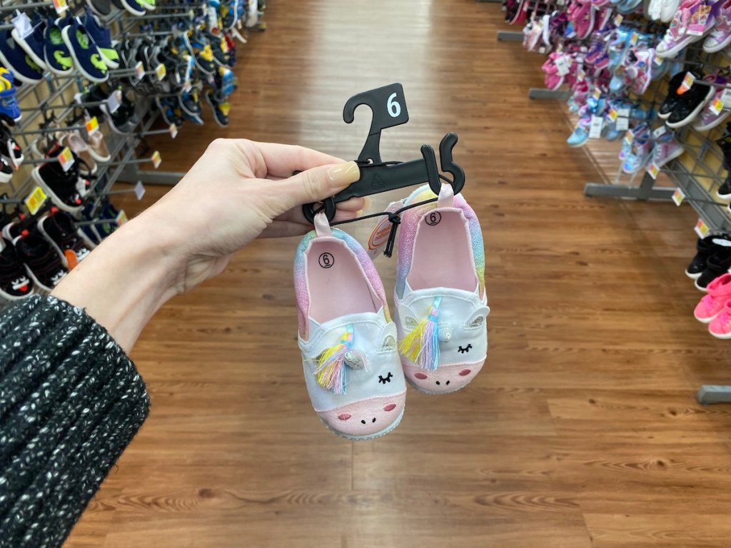 woman hand holding hanger on Wonder Nation Unicorn Slippers