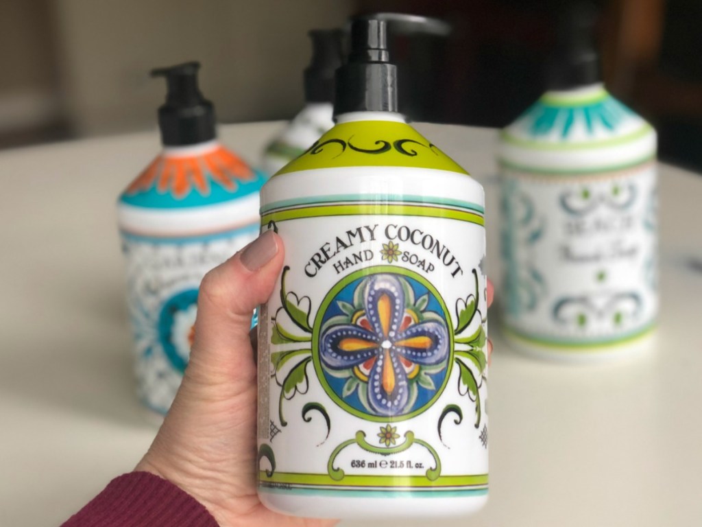 hand holding bottle of hand soap in kitchen