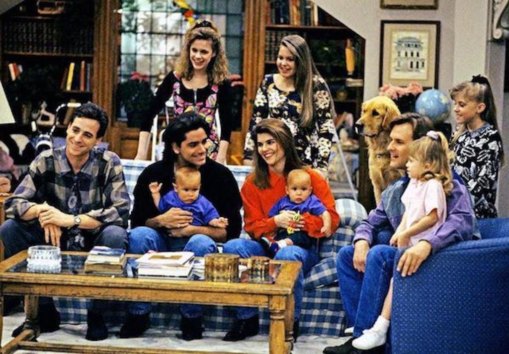 family of adults and kids sitting in living room smiling