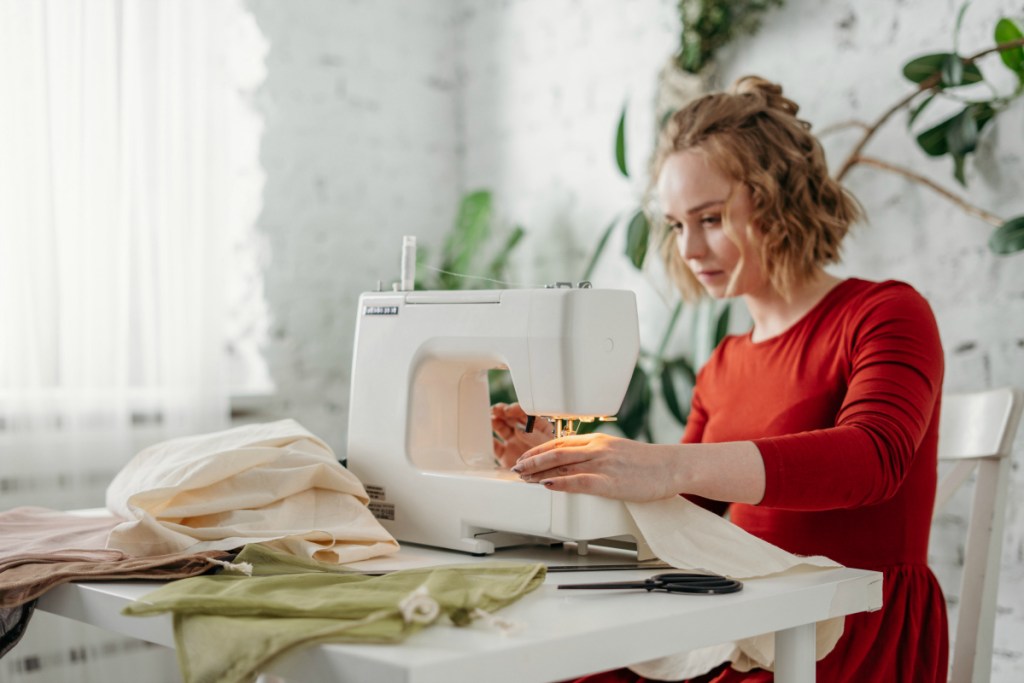 woman sewing while sitting on chair