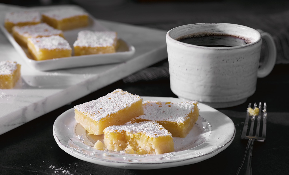 lemon bars on a plate with coffee
