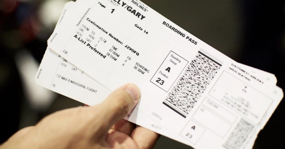 man holding one-way airline tickets for the best times to buy plane tickets and that's one way how to get cheap last minute flights 