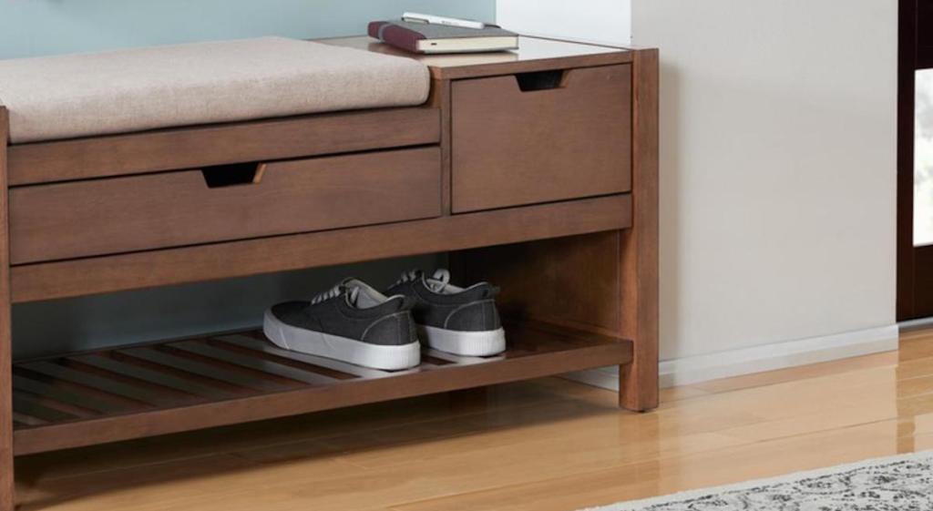brown Home Decorators Collection Wood Entryway Bench with Cushion and Concealed Storage in entry way with shoes and book on top