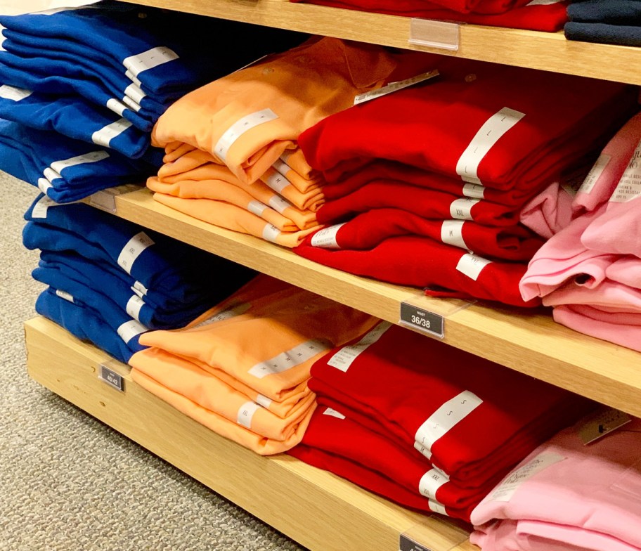 store display shelves with folded mens polo shirts in various colors