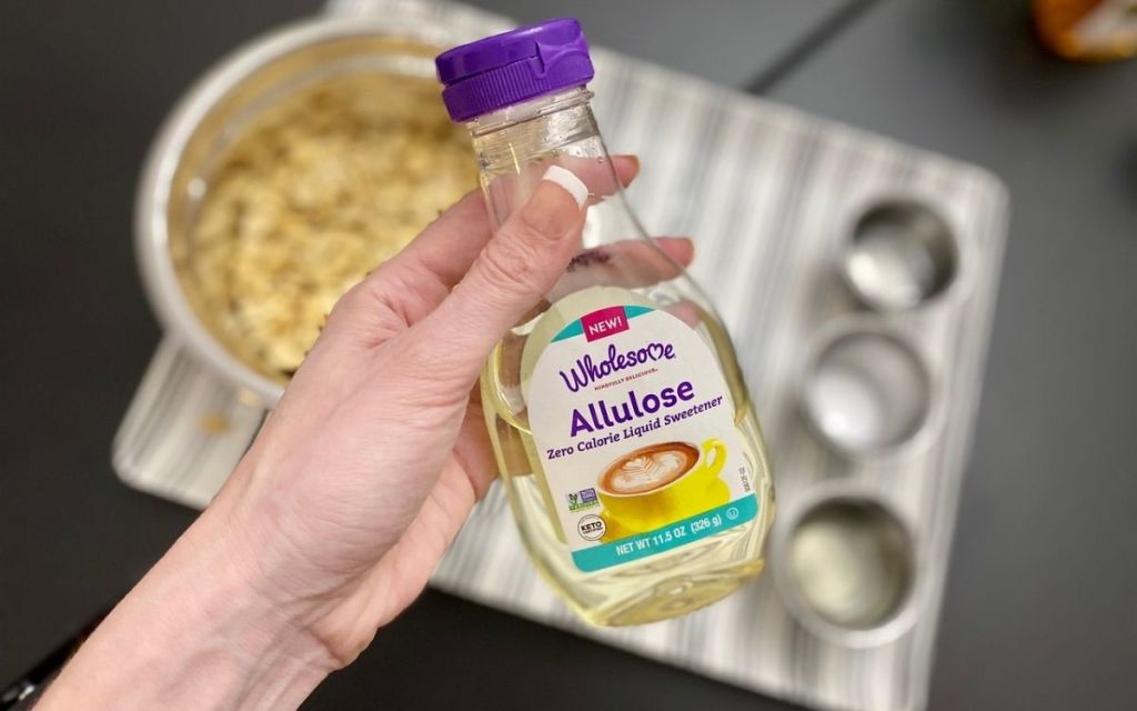 A hand holding a bottle of liquid allulose sweetener