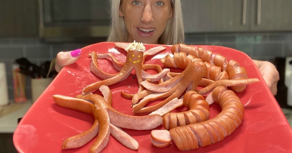 woman holding plate with silly and fun hot dogs 
