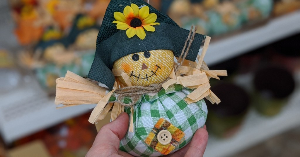 individual Harvest Inspired Scarecrow Tabletop Decor being held in hand at dollar tree