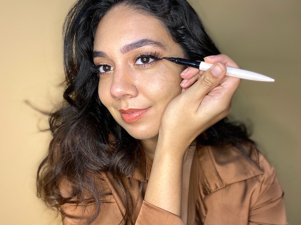 woman putting on liquid eyeliner 