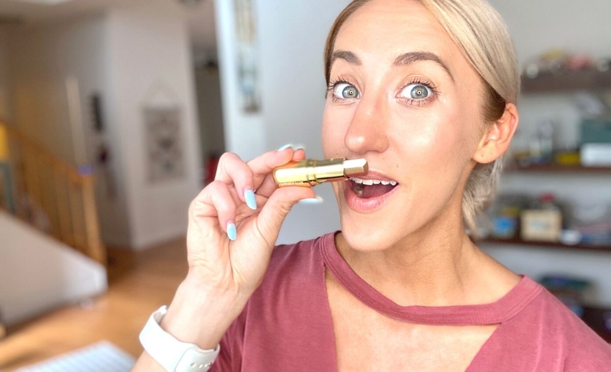 A woman smelling a winky lux lip balm