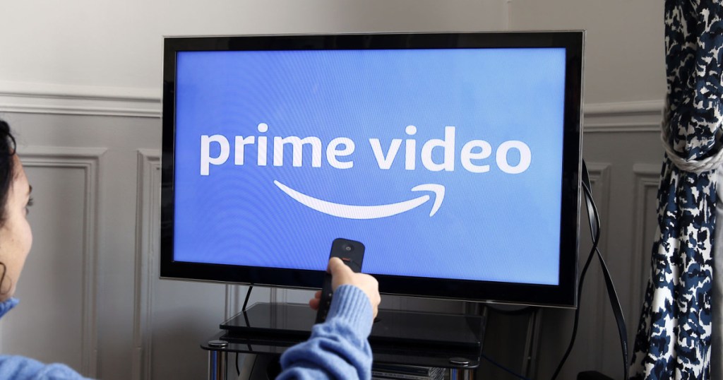 woman holding remote to tv
