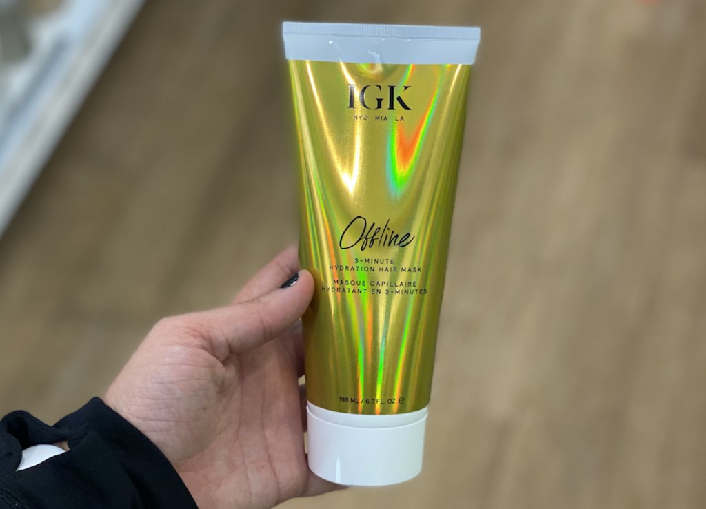 hand holding bottle of IGK Offline 3-Minute Hydration Hair Mask