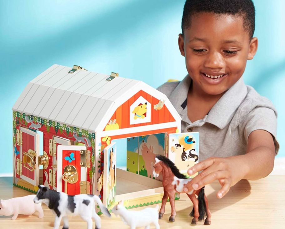 boy playing with a toy barn