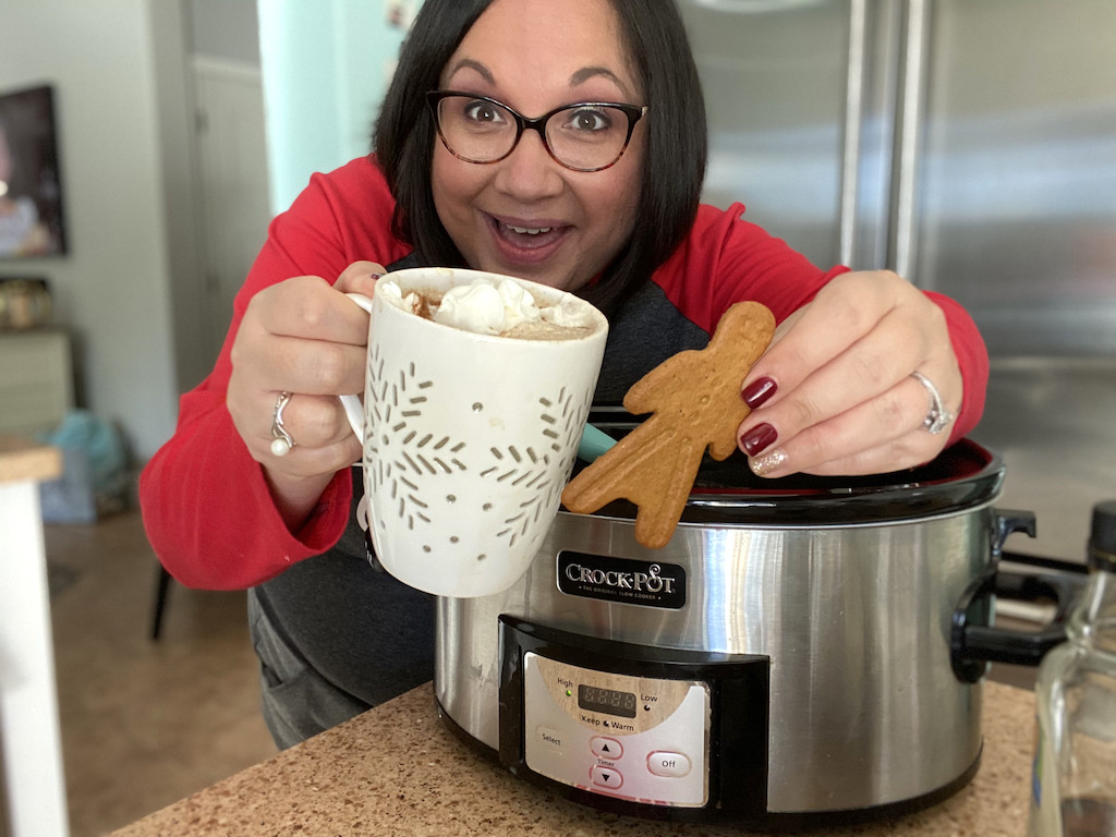 woman holding out gingerbread latte and gingerbread man