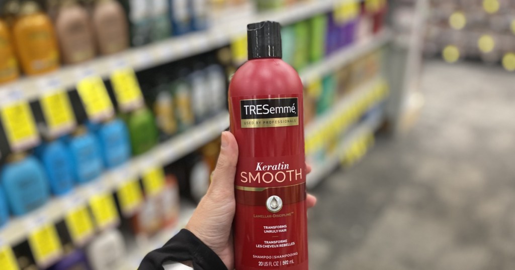 hand holding red bottle of shampoo