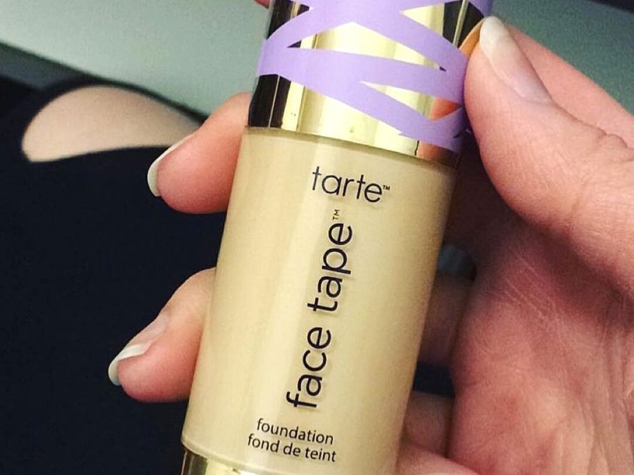 hand holding tarte face tape foundation bottle 
