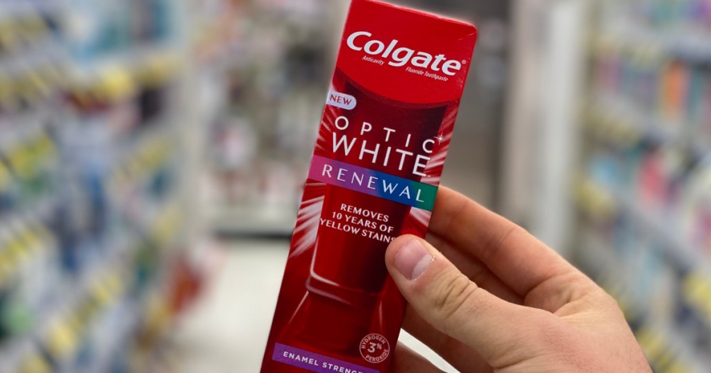 hand holding red box of toothpaste