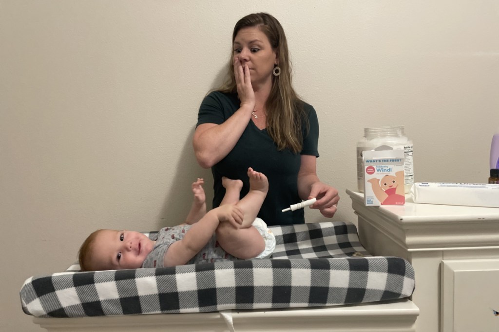 woman holding gass passer with baby in nursery 