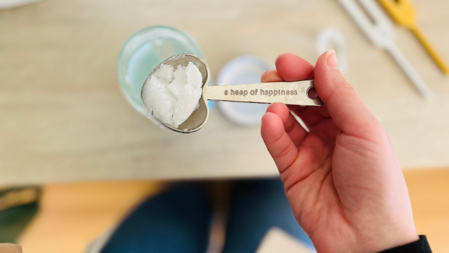 hand holding spoonful of coconut oil