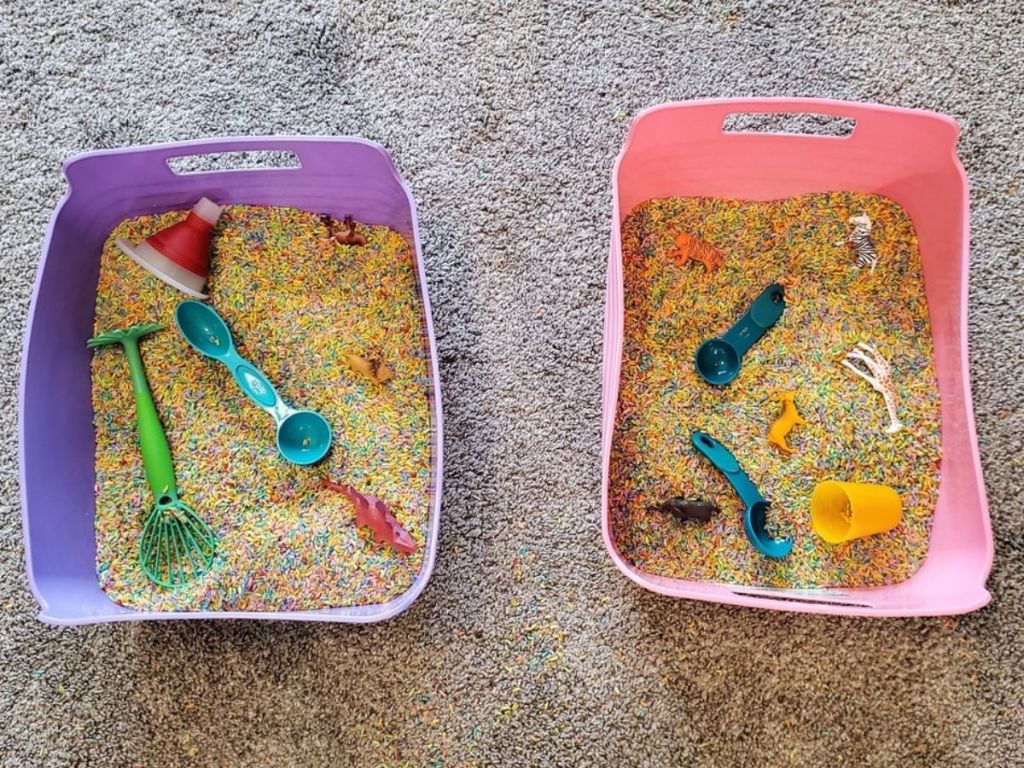purple and pink bins filled with colored rice and toys