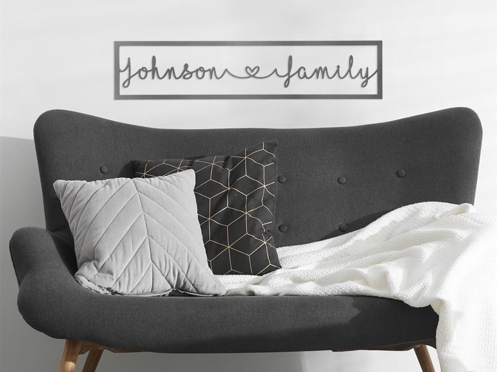 family name sign on wall above couch