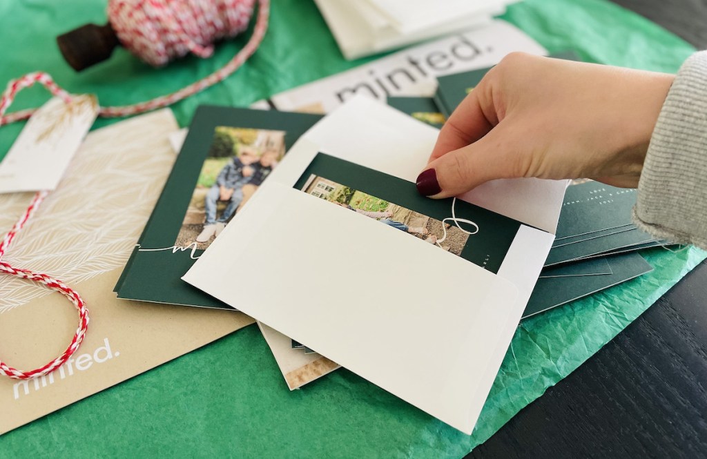 hand pulling card out of white envelope