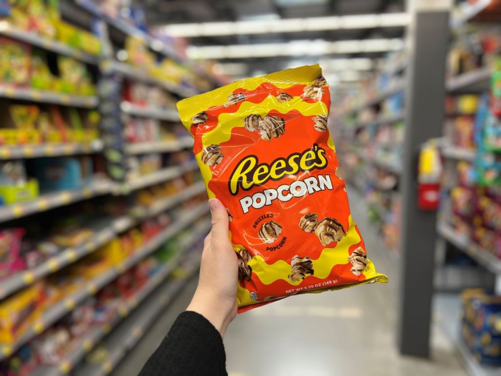 Hand holding a bag of Reese's Popcorn