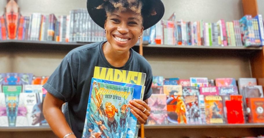 woman holding up comic books
