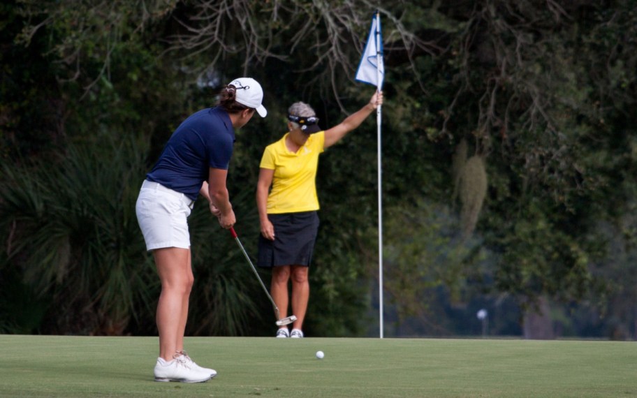 two people golfing on a course thanks to random scholarships 