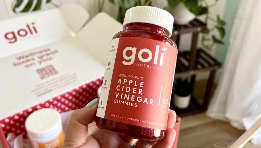 hand holding a bottle of goli apple cider vinegar gummy supplements