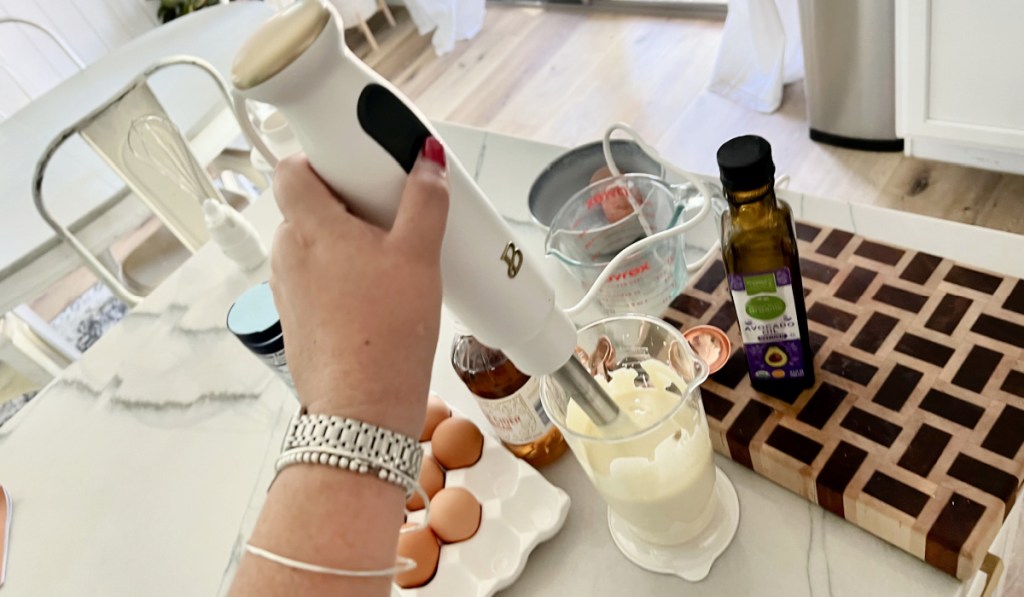 woman using immersion blender to make mayo