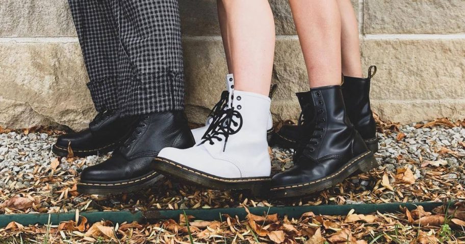 three people wearing Dr. Martens Boots that are cheaper when you convert kids sizes to women's sizes