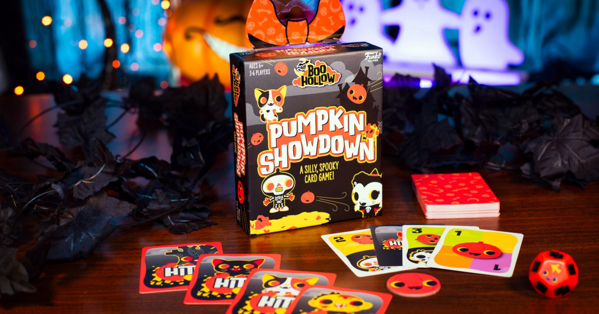 funko bool hollow pumpkin showdown card game and box displayed on a table surrounded by Halloween decorations
