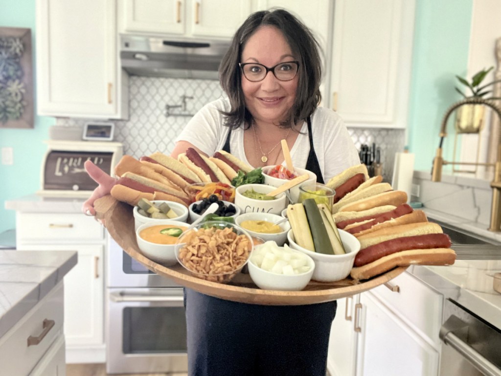 woman holding a snack board hot dog bar