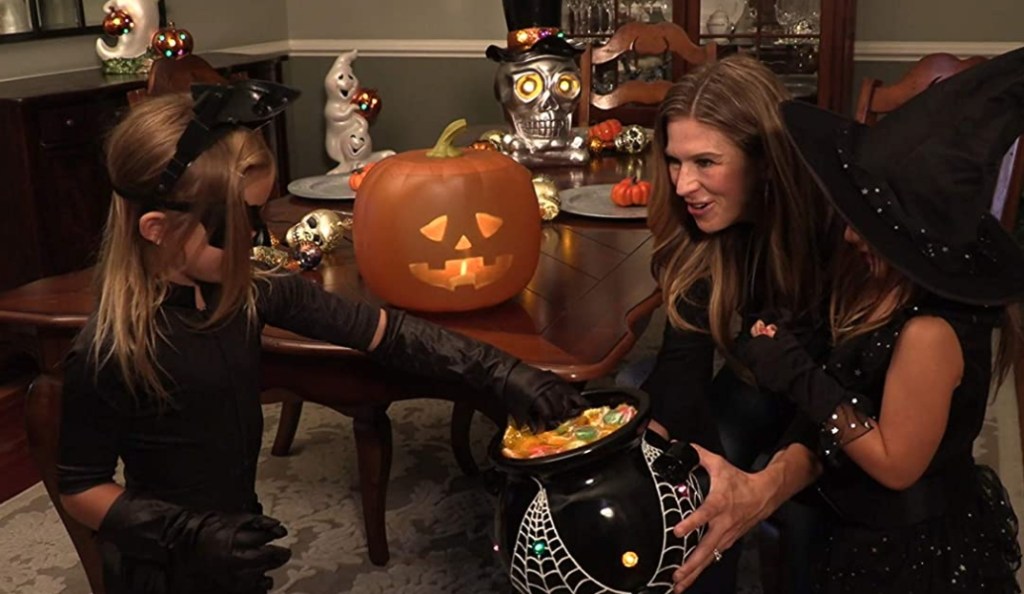 woman handing out Halloween candy
