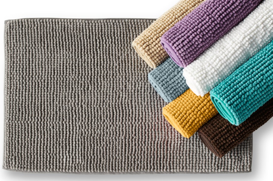 Grey bath rug with other colors rolled up on the side