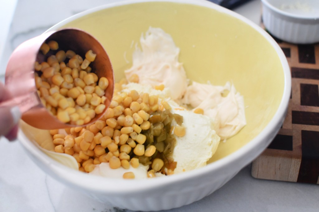 adding corn to mexican corn dip