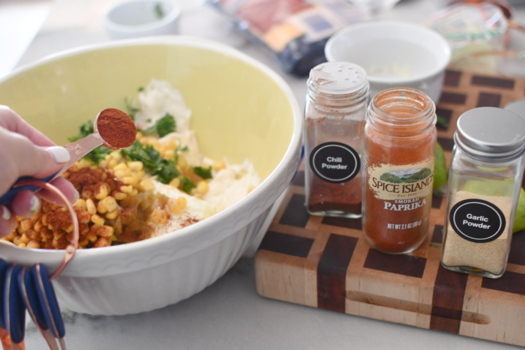 adding spices to corn dip
